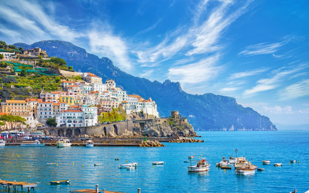 Beautiful Amalfi on hills leading down to coast, comfortable beaches and azure sea in Campania, Italy. Amalfi is most popular travel and holyday destination in Europe.